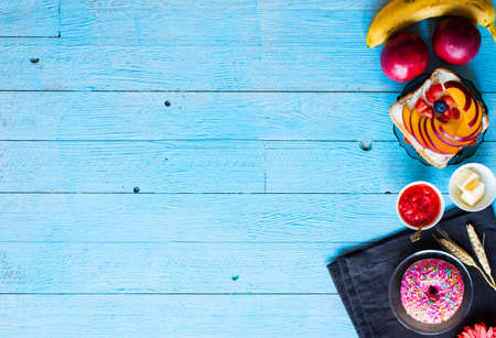 Delicious healthy breakfast, fruit sandwiches with different fillings, cheese, banana, strawberry, fishing, butter, blueberry, on a different wooden background. top viewの写真素材