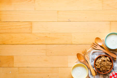 Bowl of fresh fruit with banana, apple, strawberries, apricots, blueberries, plums, whole grains, forks, spoon, free space for text. top viewの写真素材