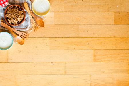 Bowl of fresh fruit with banana, apple, strawberries, apricots, blueberries, plums, whole grains, forks, spoon, free space for text. top viewの写真素材