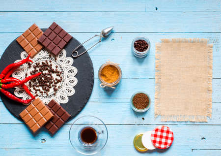 Dark chocolate and milk chocolate, with red hot chili peppers, on a wooden background, free space for textの写真素材