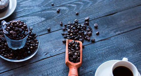Coffee beans and cup of coffee with other components on different wooden background. Free space for textの写真素材