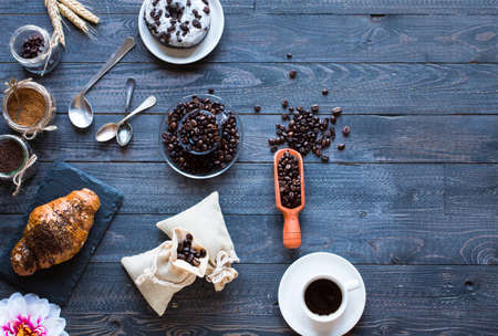 Coffee beans and cup of coffee with other components on different wooden background. Free space for textの写真素材