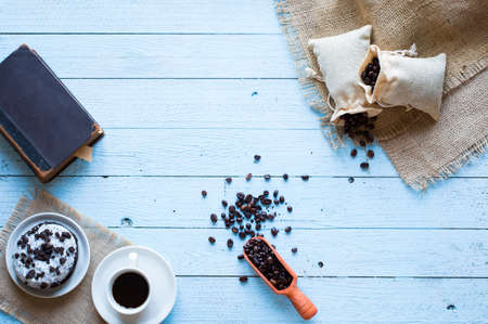 Coffee beans and cup of coffee with other components on different wooden background. Free space for textの写真素材
