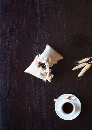 Coffee beans and cup of coffee with other components on different wooden background. Free space for textの写真素材