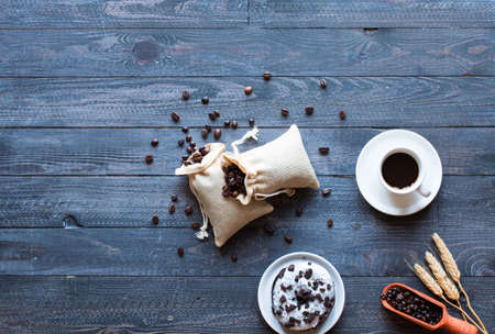 Coffee beans and cup of coffee with other components on different wooden background. Free space for textの写真素材
