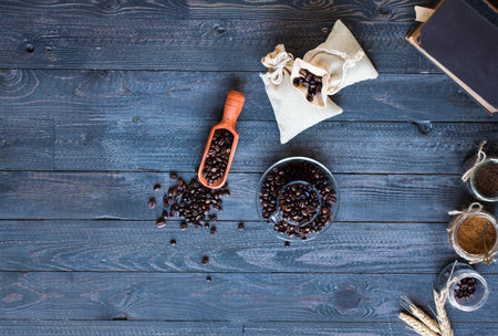 Coffee beans and cup of coffee with other components on different wooden background. Free space for...