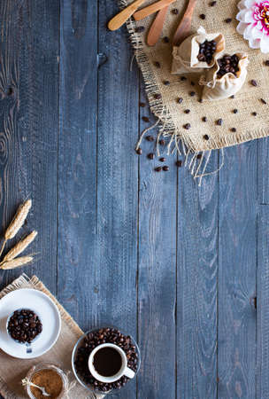 Coffee beans and cup of coffee with other components on different wooden background. Free space for textの写真素材