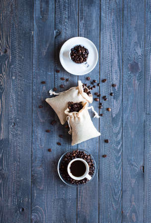 Coffee beans and cup of coffee with other components on different wooden background. Free space for textの写真素材