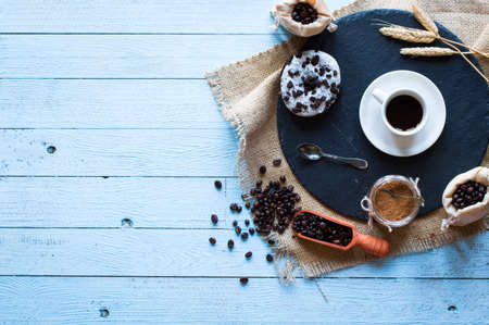 Coffee beans and cup of coffee with other components on different wooden background. Free space for textの写真素材