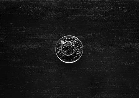 Coffee beans and cup of coffee with other components on different wooden background. Free space for textの写真素材