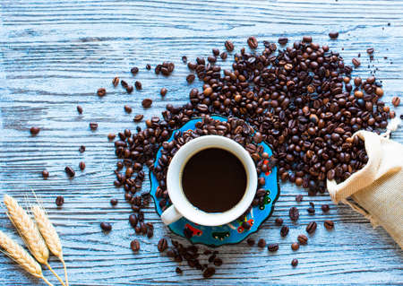 Coffee beans and cup of coffee with other components on different wooden background. free space for text. Top viewの写真素材