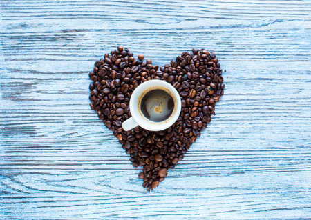 Coffee beans and cup of coffee with other components on different wooden background. free space for...