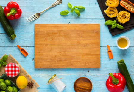 Pasta tagliatelle with pesto sauce and other vegetables on a wood background, free space for text....