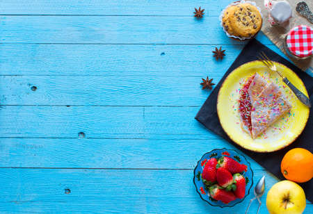 Fresh homemade crepes served on a plate with strawberries and blueberries, on a light blue wooden background, free space for text. Top viewの写真素材