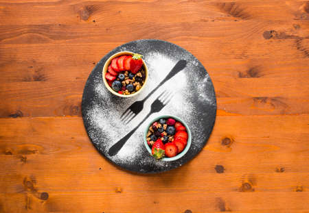 Cereal. Breakfast with muesli, and fresh fruits in bowls on a rustic wooden background, free space for textの写真素材
