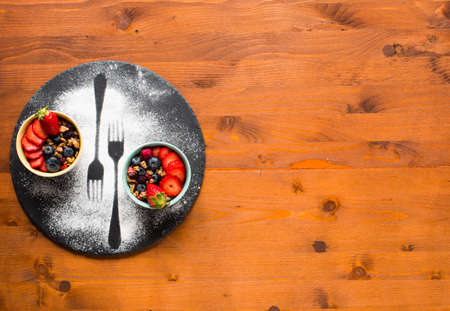 Cereal. Breakfast with muesli, and fresh fruits in bowls on a rustic wooden background, free space for textの写真素材
