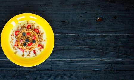 Homemade pancakes with fresh berries, strawberries, blueberries and maple syrup on a dark wooden background. Free space for textの写真素材