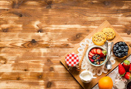 Cereal. Breakfast with muesli, and fresh fruits in bowls on a rustic wooden background, free space for textの写真素材