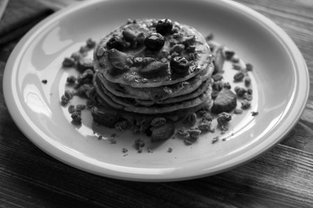 Homemade pancakes with fresh berries, strawberries, blueberries and maple syrup on a wooden...
