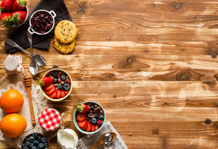 Cereal. Breakfast with muesli, and fresh fruits in bowls on a rustic wooden background, free space for textの写真素材
