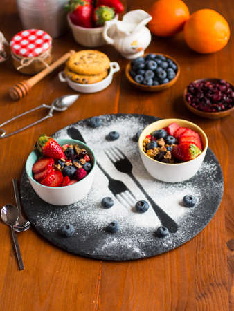 Cereal. Breakfast with muesli, and fresh fruits in bowls on a rustic wooden background, free space for textの写真素材
