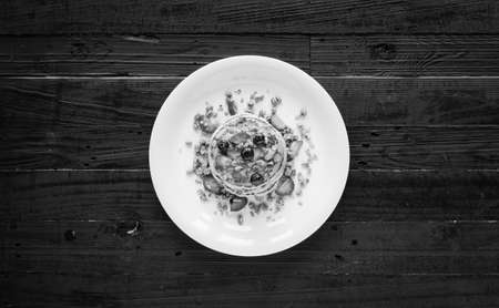 Homemade pancakes with fresh berries, strawberries, blueberries and maple syrup on a dark wooden background. Free space for textの写真素材