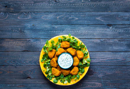 Chicken nuggets with yogurt sauce on a wooden background free space for textの写真素材