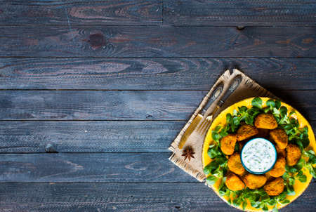 Chicken nuggets with yogurt sauce on a wooden background free space for textの写真素材