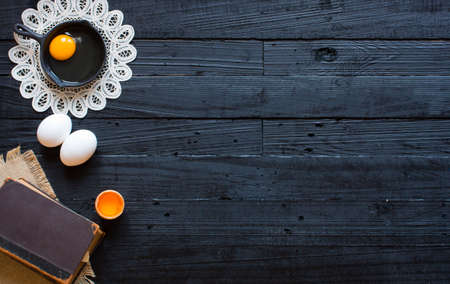 Chicken egg on a dark wooden background, free space for text. Top viewの写真素材