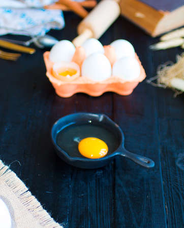 Chicken egg on a dark wooden background, free space for text. Top viewの写真素材