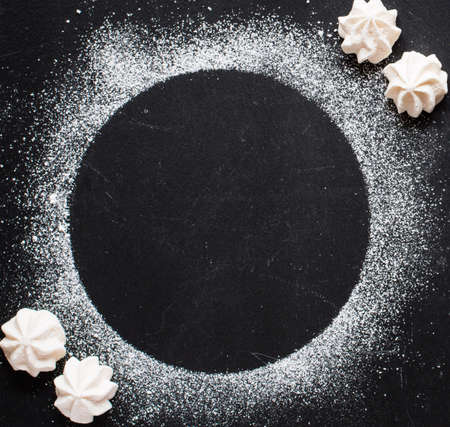Sweet white meringue on a black wooden background, free space for text. Top viewの写真素材