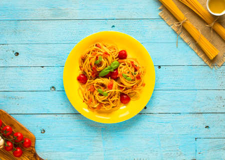 Pasta with tomatoes sauce and other components on a light blue wooden background free space for text. Top viewの写真素材