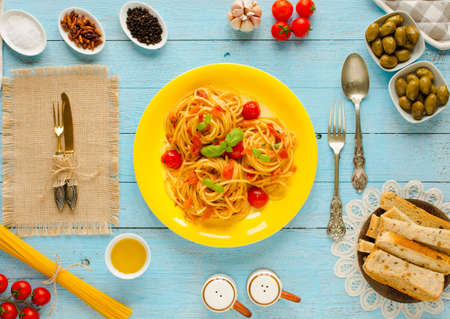Pasta with tomatoes sauce and other components on a light blue wooden background free space for text. Top viewの写真素材