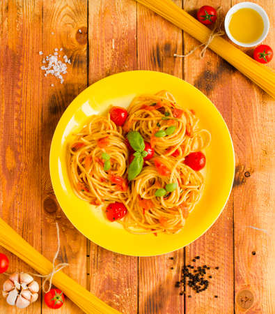 Pasta with tomatoes sauce and other components on a wooden background free space for text. Top viewの写真素材