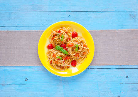 Pasta with tomatoes sauce and other components on a light blue wooden background free space for text. Top viewの写真素材