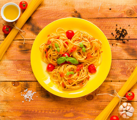Pasta with tomatoes sauce and other components on a wooden background free space for text. Top view