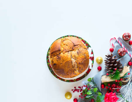 Italian chocolate panettone Christmas cake with bauble decorations, candles,pine cones, on a wooden background. Free space for textの写真素材
