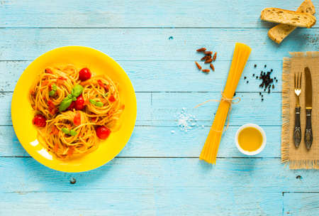Pasta with tomatoes sauce and other components on a light blue wooden background free space for text. Top viewの写真素材