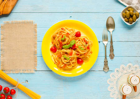 Pasta with tomatoes sauce and other components on a light blue wooden background free space for text. Top viewの写真素材