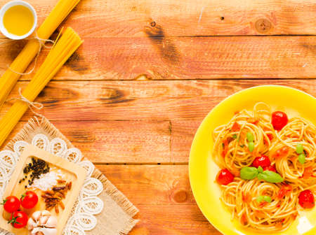Pasta with tomatoes sauce and other components on a wooden background free space for text. Top viewの写真素材