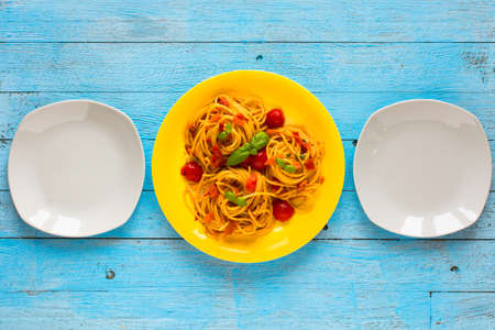 Pasta with tomatoes sauce and other components on a light blue wooden background free space for text. Top viewの写真素材