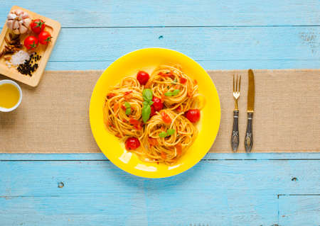 Pasta with tomatoes sauce and other components on a light blue wooden background free space for text. Top viewの写真素材