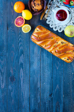 Breakfast with coffee and tea with different pastries and fruits on a wooden table free space for textの写真素材