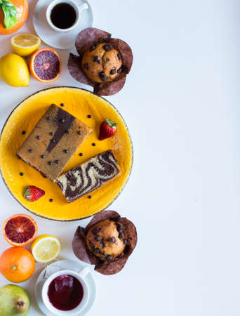 Breakfast with coffee and tea with different pastries and fruits on  a white wooden table free space for textの写真素材