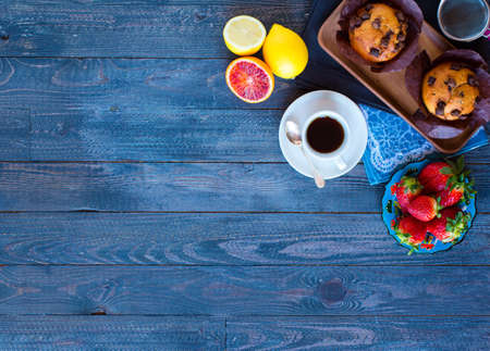 Breakfast with coffee and tea with different pastries and fruits on a wooden table free space for textの写真素材