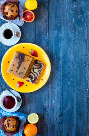 Breakfast with coffee and tea with different pastries and fruits on a wooden table free space for textの写真素材
