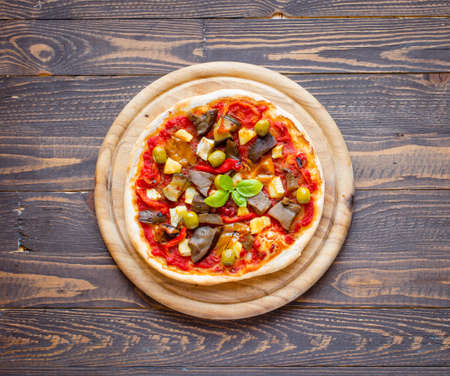Fresh homemade pizza with different vegetables on a wooden background free space for textの写真素材
