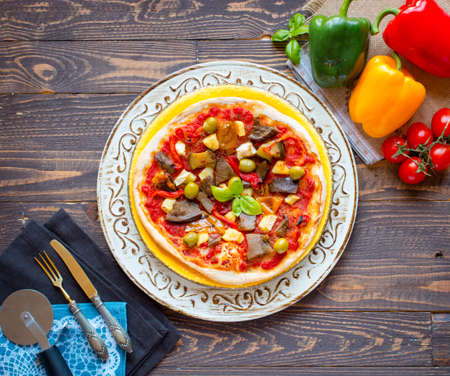 Fresh homemade pizza with different vegetables on a wooden background free space for textの写真素材