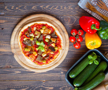 Fresh homemade pizza with different vegetables on a wooden background free space for textの写真素材