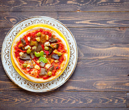 Fresh homemade pizza with different vegetables on a wooden background free space for textの写真素材